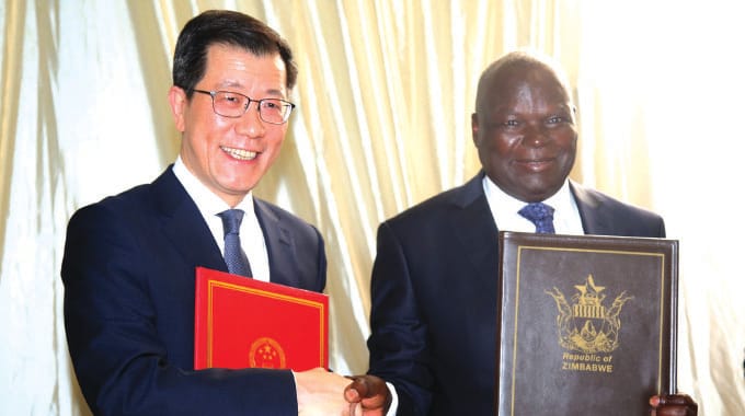 Public Works Minister July Moyo shakes hands with Chinese Ambassador to Zimbabwe Guo Shaochun after the signing ceremony at State House in Harare yesterday