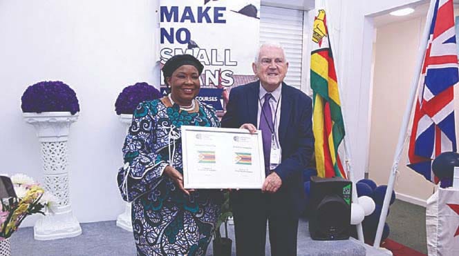 First Lady Dr Auxillia Mnangagwa receives scholarship agreement from Mr Graham Rainbird an official at Cornerstone College Cambridge