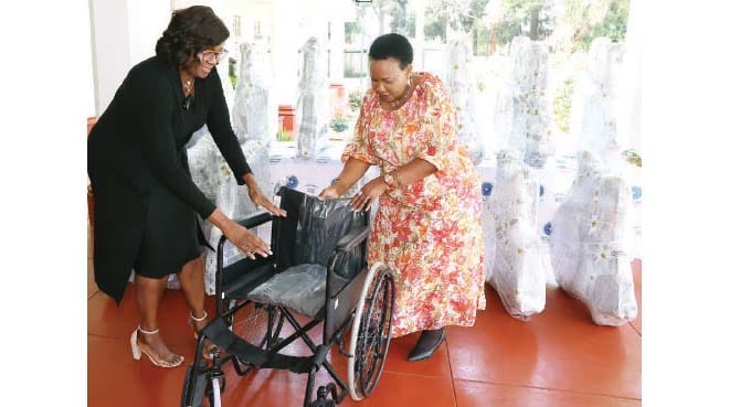 Mrs Priscilla Zvobgo hands over one of the wheelchairs to Angel of Hope Foundation patron First Lady Dr Auxillia Mnangagwa on behalf of IDBZ at Zimbabwe House yesterday. — Pictures: John Manzongo