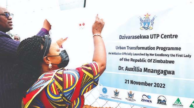 First Lady Dr Auxillia Mnangagwa, who is patron of Agriculture-for-She, is assisted by Secretary for Provincial Affairs and Devolution for Harare Metropolitan Province Mr Tafadzwa Muguti to unveil a plaque during the launch of Urban Transformation Programme in Dzivaresekwa, Harare on Monday. - Pictures: John Manzongo