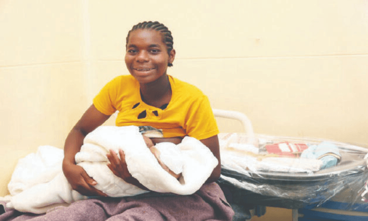 One of the jubilant mothers who received new born baby kits from First Lady Dr Auxillia Mnangagwa breastfeeds her baby in Harare on Christmas day.