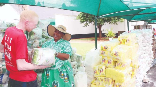 First Lady Dr Auxillia Mnangagwa hands over Christmas food hampers to Mr Selby Morris Mubaiwa of Mutare Probation Hostel at Zimbabwe House yesterday