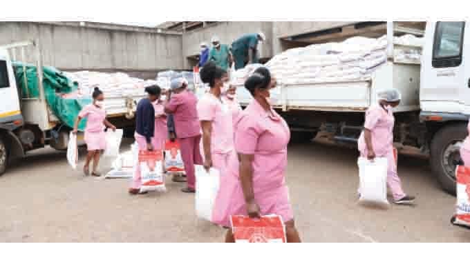 Medical staff from Parirenyatwa Group of Hospitals, Sally Mugabe and Chitungwiza Central Hospitals offload mealie-meal and rice donated by Health Ambassador, First Lady Dr Auxillia Mnangagwa (Pictures by John Manzongo and Obey Sibanda)