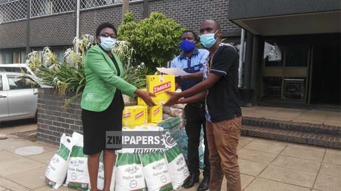 SOS family care coordinator Mrs Tiafora Ngwenya receiving goods from the Angel of Hope Foundation from provincial social development officer Mr Godwin Bongwe, picture by Fungai Lupande