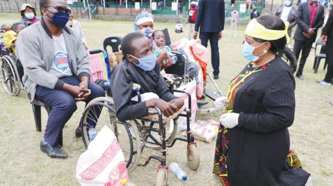 First Lady Auxillia Mnangagwa hands over groceries to a boy living with disability during her Covid-19 interactive awareness campaign in Mutare last year. — Picture: John Manzongo