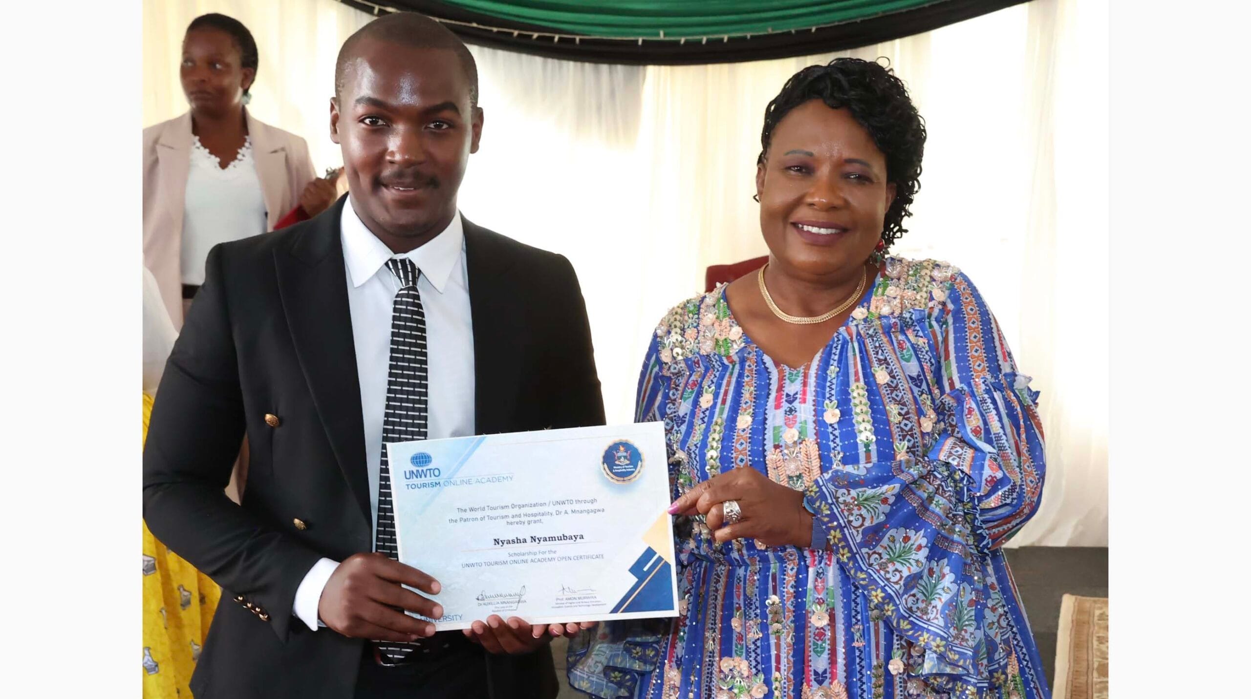 Patron of Tourism and Hospitality First Lady Dr Auxillia Mnangagwa hands over a scholarship from United Nations Tourism 