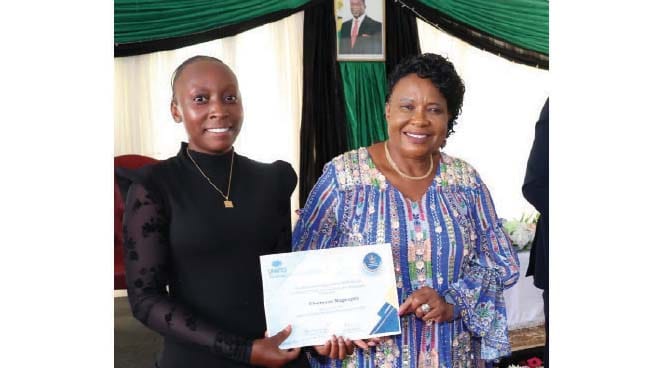 Patron of Tourism and Hospitality First Lady Dr Auxillia Mnangagwa hands over a scholarship from United Nations Tourism to Charmaine Mugwagwa at Zimbabwe House yesterday.