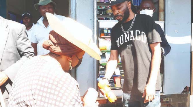 A man hands over a soft drink to Environment and Tourism patron First Lady Dr Auxillia Mnangagwa so she could cool down and also as a way of appreciating her tireless efforts in clean-up campaigns in Harare yesterday