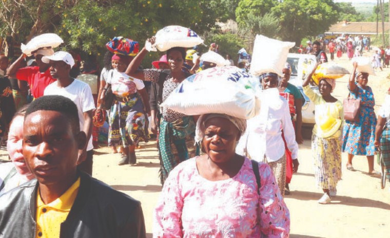 People carry home the food hampers they received from First Lady Dr Auxillia Mnangagwa in Hurungwe yesterday. — Pictures: John Manzongo