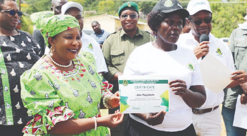 Environment and Wildlife patron First Lady Dr Auxillia Mnangagwa hands over a certificate to Mrs Jane Pasipamire for completing fish farming training at the Joint commemorations of the Africa environment day / wangari maathai day, world wildlife day, international day of forests and world meteorological day 2024 in Buhera yesterday