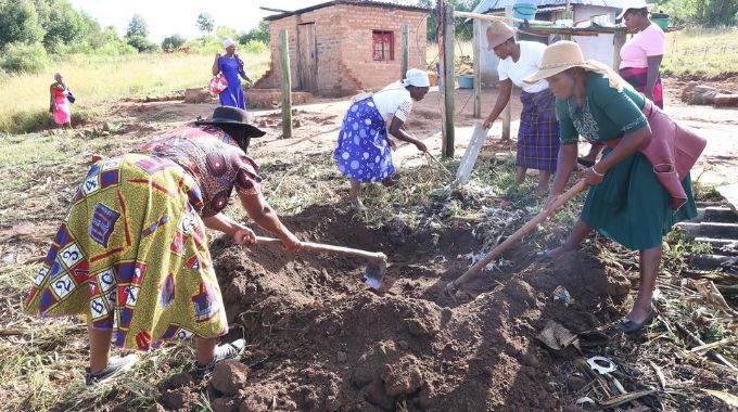 Women dig a refuse pit at Gogo Ellah Guta’s homestead in Mutasa, Manicaland yesterday