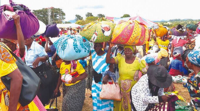 People, among them elderly women, those living with disabilities, child-headed families and those living with albinism, among other vulnerable groups, carry home blankets, clothes, food hampers and toiletries among other things they received from First Lady Dr Auxillia Mnangagwa in Manicaland. — Pictures: John Manzongo