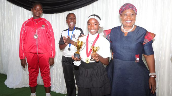 First Lady Dr Auxillia Mnangagwa celebrates and congratulates Tyra Mbofana who was the overall winner in poem and speech competitions while her 1st and 2nd runner ups look on during the boot camp yesterday. – Pictures: John Manzongo