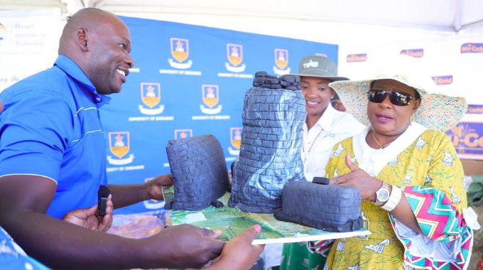 First Lady Dr Auxillia Mnangagwa looks at a cake made using mixed Zimbabwean traditional grains such as sorghum, millet, rapoko, tsubvu and masawu, which was on exhibition at the University of Zimbabwe stand during the Farm to Market and Arts festival in Harare