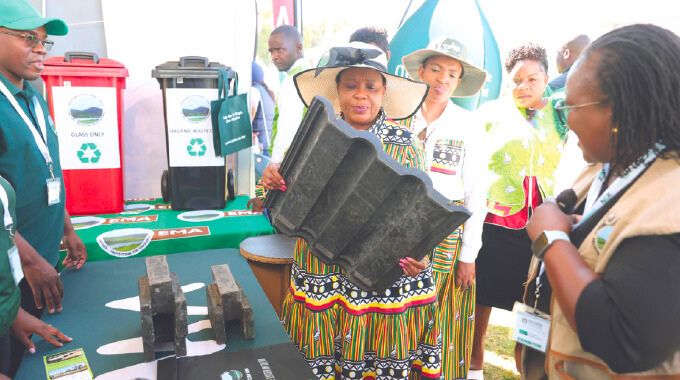 First Lady Dr Auxillia Mnangagwa looks at roofing tiles made from recycled materials on exhibition at the Environmental Management Agency stand during the Farm to Market and Arts festival in Harare