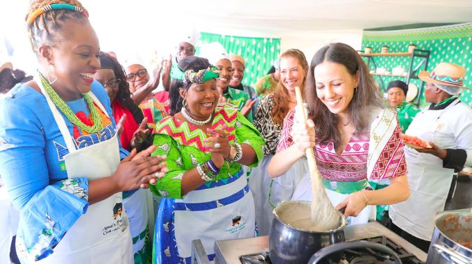 First Lady Dr Auxillia Mnangagwa teaches UN Tourism programme officer Ms Zineb Remmal how to prepare millet sadza, while UN Tourism technical coordinator Ms Maria Soledad Gaido and Malawi Minister of Tourism Ms Vera Kamtukule look on during Amai’s traditional meal cookout competition in Nyanga on Africa Day.