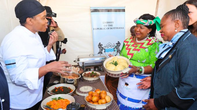 First Lady Dr Auxillia Mnangagwa listens as a chef at the Botswana stand explains her country’s traditional dishes while Botswana Ambassador to Zimbabwe Mrs Sarah Molosiwa look on during Amai’s traditional meal cookout competition in Nyanga on Africa Day.