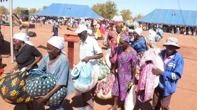 Beneficiaries carry home the blankets and food hampers they received from First Lady Dr Auxillia Mnangagwa in Sanya, Muzarabani 15 kilometres from the border with Mozambique yesterday. — Pictures: John Manzongo.