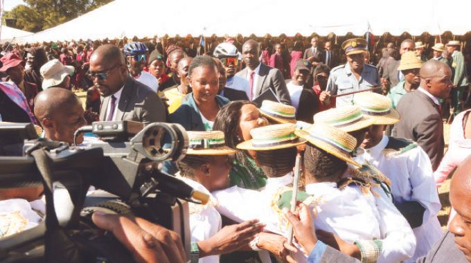 First Lady Dr Auxillia Mnangagwa is swarmed by learners who all wanted to hug her during her engagement with them on the dangers of drugs and substance abuse in Harare yesterday