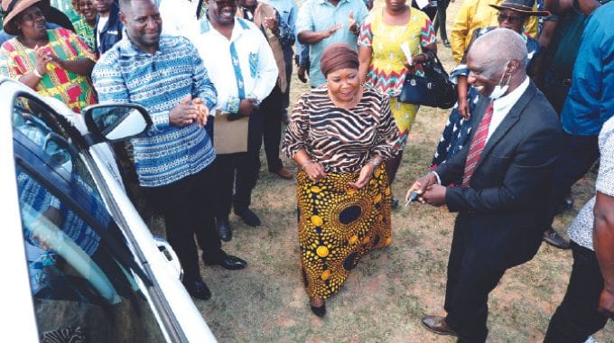 First Lady Auxillia Mnangagwa talks to Kakora Secondary acting head Mr Samuel Mangwiro (right) after the handover of a vehicle donated by President Mnangagwa, while Mashonaland Central Minister of State and Devolution, Christopher Magomo (left) looks on