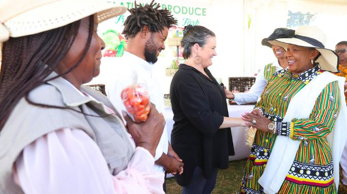 First Lady Dr Auxillia Mnangagwa is welcomed by Mashonaland East farming couple, Mr and Mrs Chengu to their stand, while the province’s Minister Aplonia Munzverengwi, looks on during the Farm to Market and Arts festival in Harare