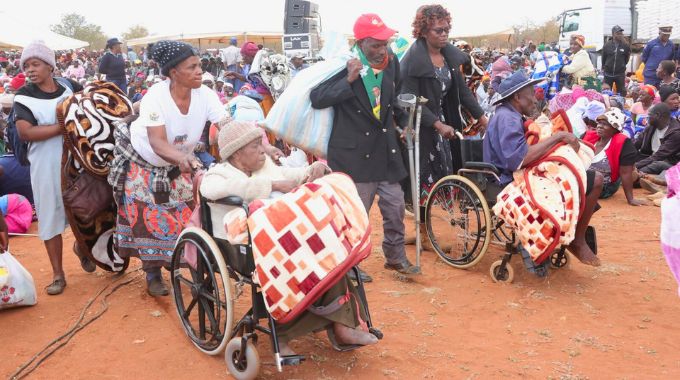 People living with disabilities and other vulnerable groups walk away with blankets and food hampers they received from First Lady Dr Auxillia Mnangagwa in Chingwizi. — Pictures: John Manzongo