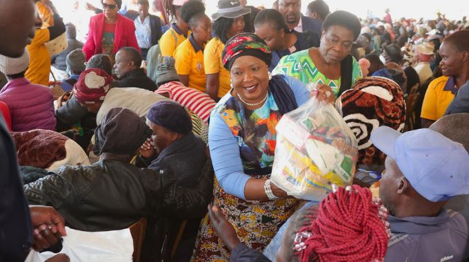 First Lady Dr Auxillia Mnangagwa is assisted by Minister of State and Devolution for Bulawayo Judith Ncube to distribute blankets, winter jackets and food hampers to the elderly, those living with disabilities, child headed families and vulnerable members of society from Bulawayo, Matabeleland South and Matabeleland North yesterday.