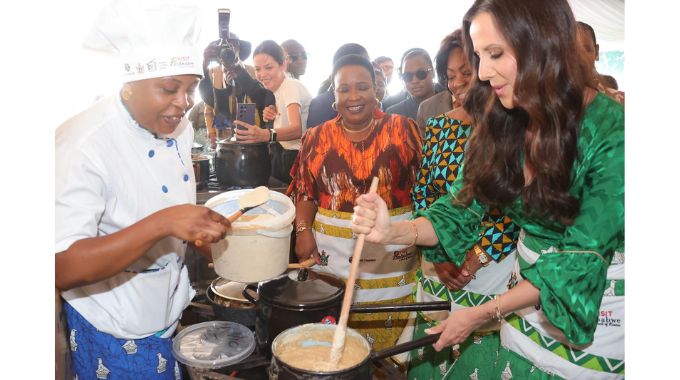 Serbian First Lady Tamara Vucic cooks sadza while First Lady Dr Auxillia Mnangagwa and other delegates observe during the UN Tourism Regional forum on gastronomy tourism for Africa in Victoria Falls yesterday