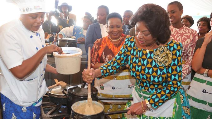 First Lady Dr Auxillia Mnangagwa and other delegates look on as Angolan First Lady Anna Dias Lourenco cooks sadza with mealie meal from Zimbabwean traditional grains during the UN Tourism Regional forum on gastronomy tourism for Africa in Victoria Falls yesterday