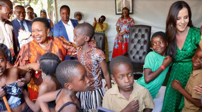 First Lady Dr Auxillia Mnangagwa and her Serbian counterpart Mrs Tamara Vucic hug Baobab primary school pupils during the donation of tablets to enhance their ICT capacity at their school in Victoria Falls on Friday.