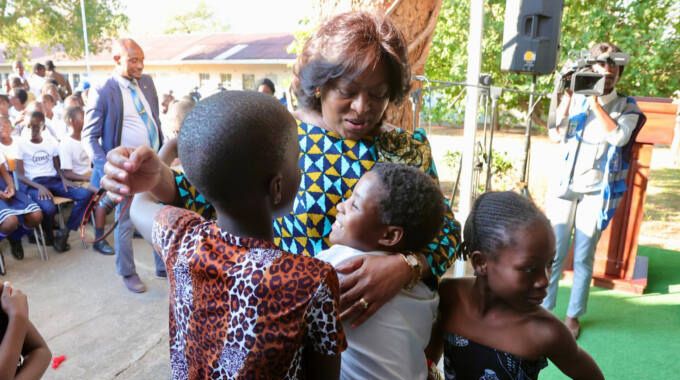 Angolan First Lady Anna Dias Lourenco hugs Baobab primary school pupils during the donation of tablets by Serbian First Lady Tamara Vucic at their school in Victoria Falls on Friday.