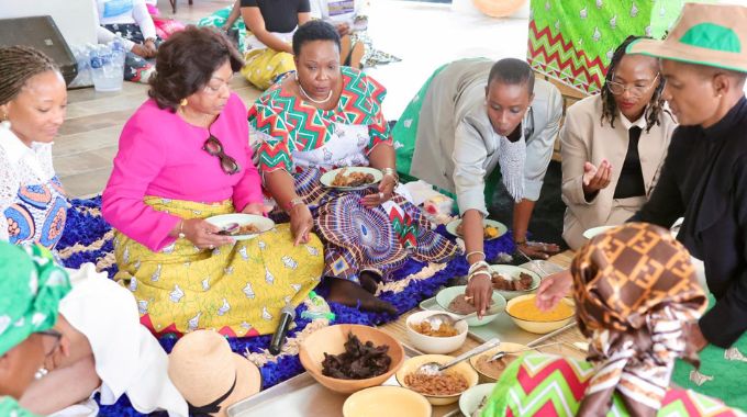 First Lady Dr Auxillia Mnangagwa and her visitors taste Zimbabwean traditional dishes which were prepared by girls during nhanga programme in Victoria Falls