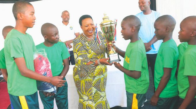 First Lady Dr Auxillia Mnangagwa hands over a trophy to the boys after they won soccer and volleyball matches during her inaugural national boys camp. – Pictures: John Manzongo