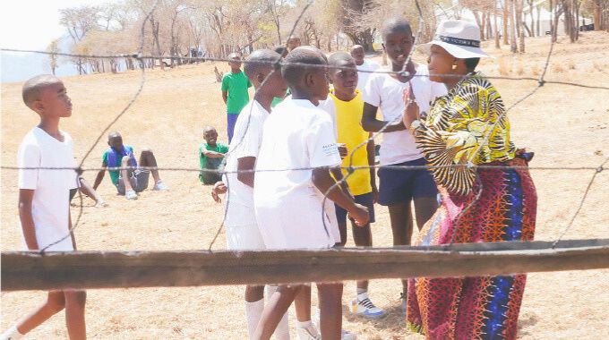 First Lady Dr Auxillia Mnangagwa tips boys on the need for teamwork as they play volleyball during her inaugural national boys camp