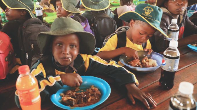 Learners enjoy their meals cooked by First Lady Dr Auxillia Mnangagwa under her schools feeding programme in Mashonaland East yesterday