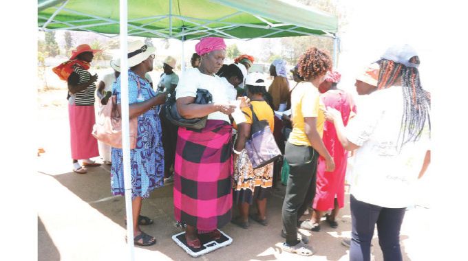 Women checking their weight during a mobile medical outreach, courtesy of Angel of Hope Foundation patron First Lady Dr Auxillia Mnangagwa in Harare.