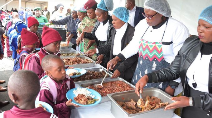 Learners receive food during a school feeding programme organised by First Lady Dr Auxillia Mnangagwa in Midlands