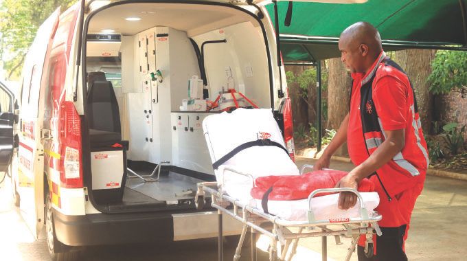 Discovery Ambulance Services practitioner-in-charge, Mr Elliot Chivige demonstrates the self-loading stretcher from the Intensive Care Unit (ICU) mobile ambulance donated to Health Ambassador First Lady Dr Auxillia Mnangagwa in Harare yesterday