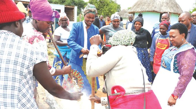 First Lady Dr Auxillia Mnangagwa advises women on how to prepare rice with peanut butter as they prepared meals during her school feeding programme in Masvingo yesterday