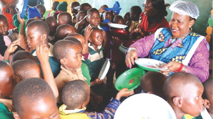 Schoolchildren compete to hand over their empty plates to First Lady Dr Auxillia Mnangagwa