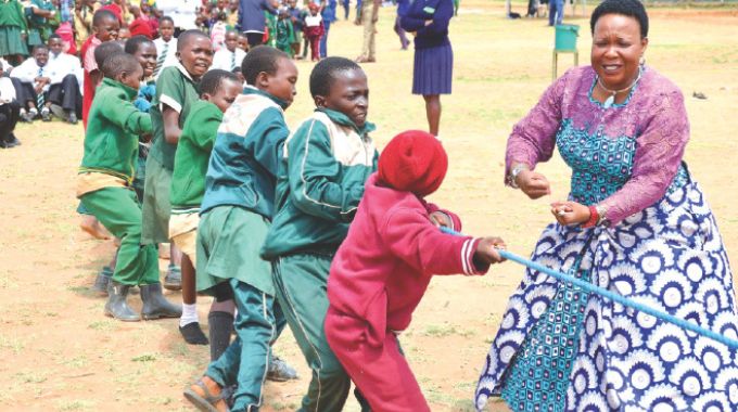 Schoolchildren participate in a tug of war, while being cheered by First Lady Dr Auxillia Mnangagwa during an interactive session after a school feeding programme yesterday