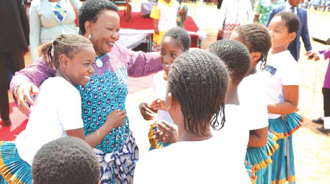 First Lady Dr Auxillia Mnangagwa hugs girls after they performed their Shangani traditional dance in Masvingo yesterday