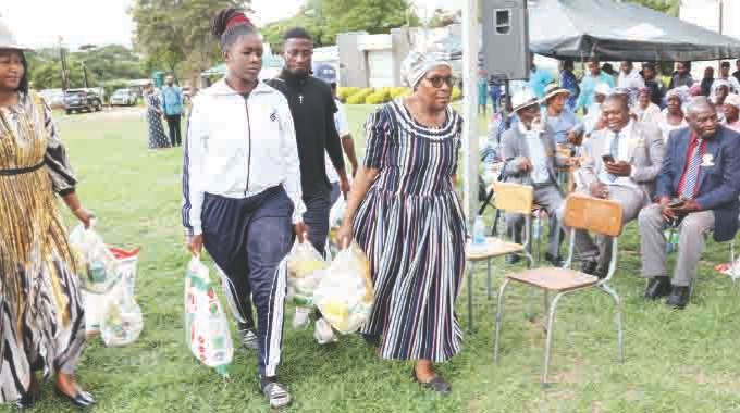 Minister of State and Devolution for Mashonaland East Aplonia Munzverengwi and Deputy Minister of Sports, Recreation, Arts and Culture Emily Jesaya distribute hampers donated to the elderly by First Lady Dr Auxillia Mnangagwa in Mashonaland East on Sunday