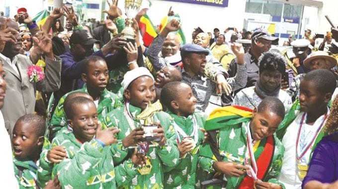 Children from Dr Auxillia Mnangagwa Children’s Home in Chiredzi display their trophy and medals as they received a rousing welcome upon their arrival at the Robert Gabriel Mugabe International Airport on Friday