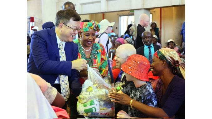 Chinese Ambassador to Zimbabwe Zhou Ding distributes hampers donated by Angel of Hope Foundation in Chitungwiza yesterday.