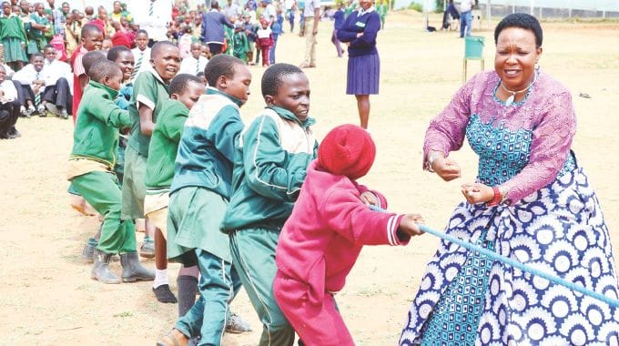 Schoolchildren participate in a tug of war competition while being cheered by First Lady Dr Auxillia Mnangagwa during an interactive session and team building exercises after a school feeding programme