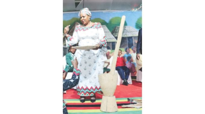 Patron of culture and heritage First Lady Dr Auxillia Mnangagwa shows and teaches schoolchildren about the various traditional utensils and their use such as winnowing basket, mortar and pestle among others in Harare yesterday. — Pictures: John Manzongo