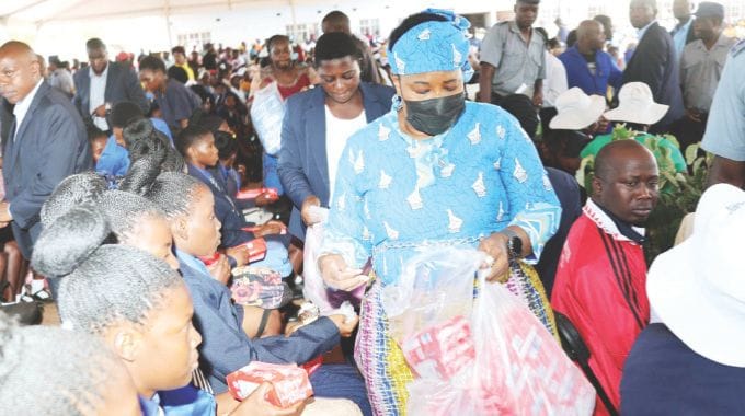 First Lady Dr Auxillia Mnangagwa hands over sanitary pads to school girls in Gokwe yesterday