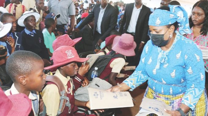 First Lady Dr Auxillia Mnangagwa hands over books to schoolchildren in Gokwe yesterday. – Pictures: John Manzongo