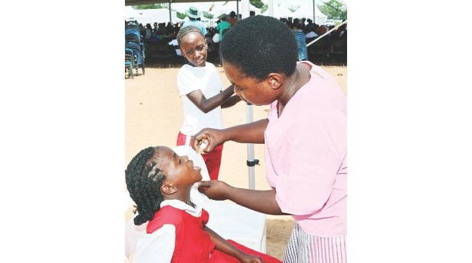 A health worker immunises a school girl against polio during a free medical outreach organised by Health Ambassador First Lady Dr Auxillia Mnangagwa in Gokwe yesterday. – Pictures: John Manzongo